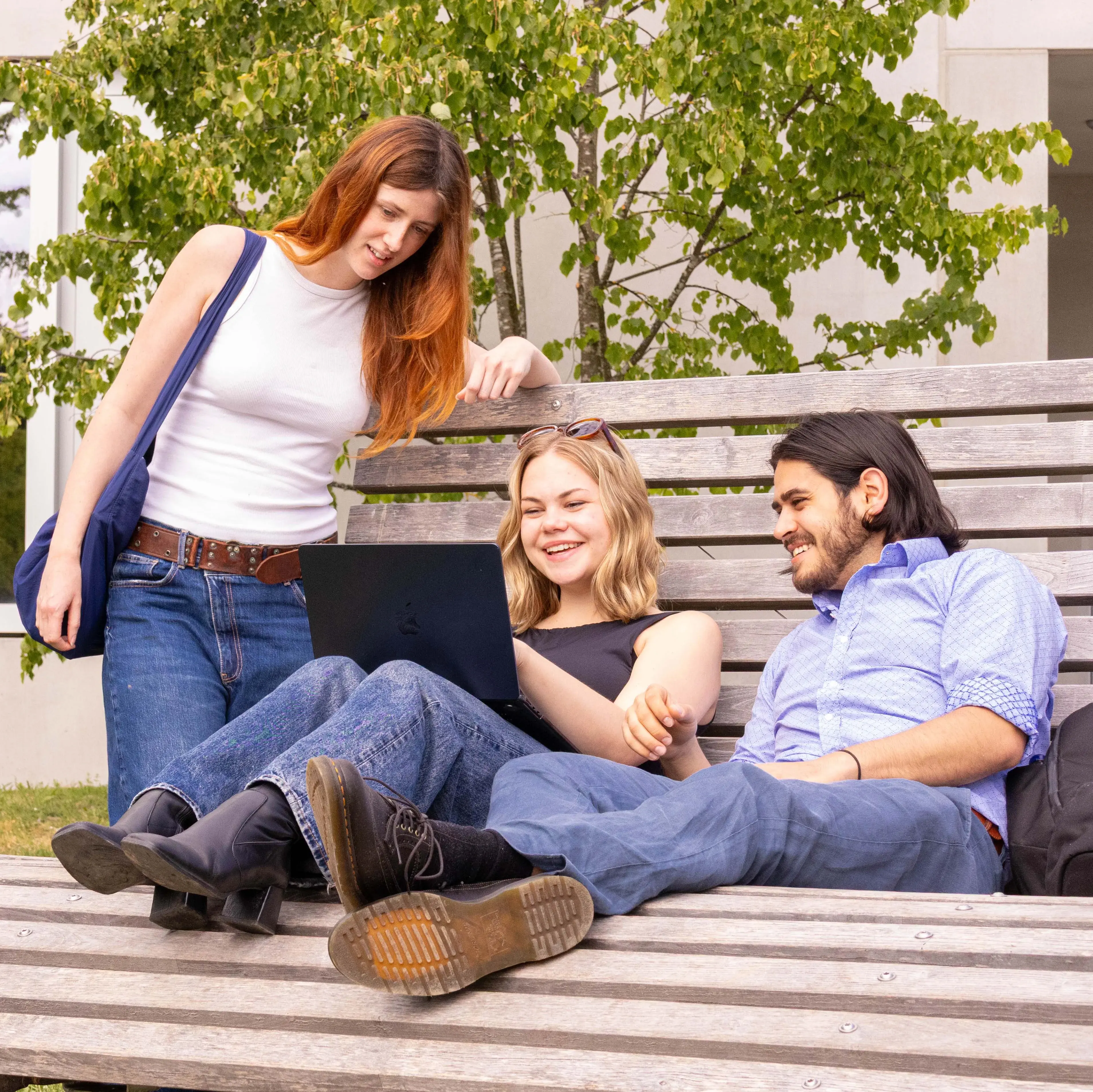 Studierende verbringen ihre Pause auf den Liegebänken vor der Hochschule der Medien.