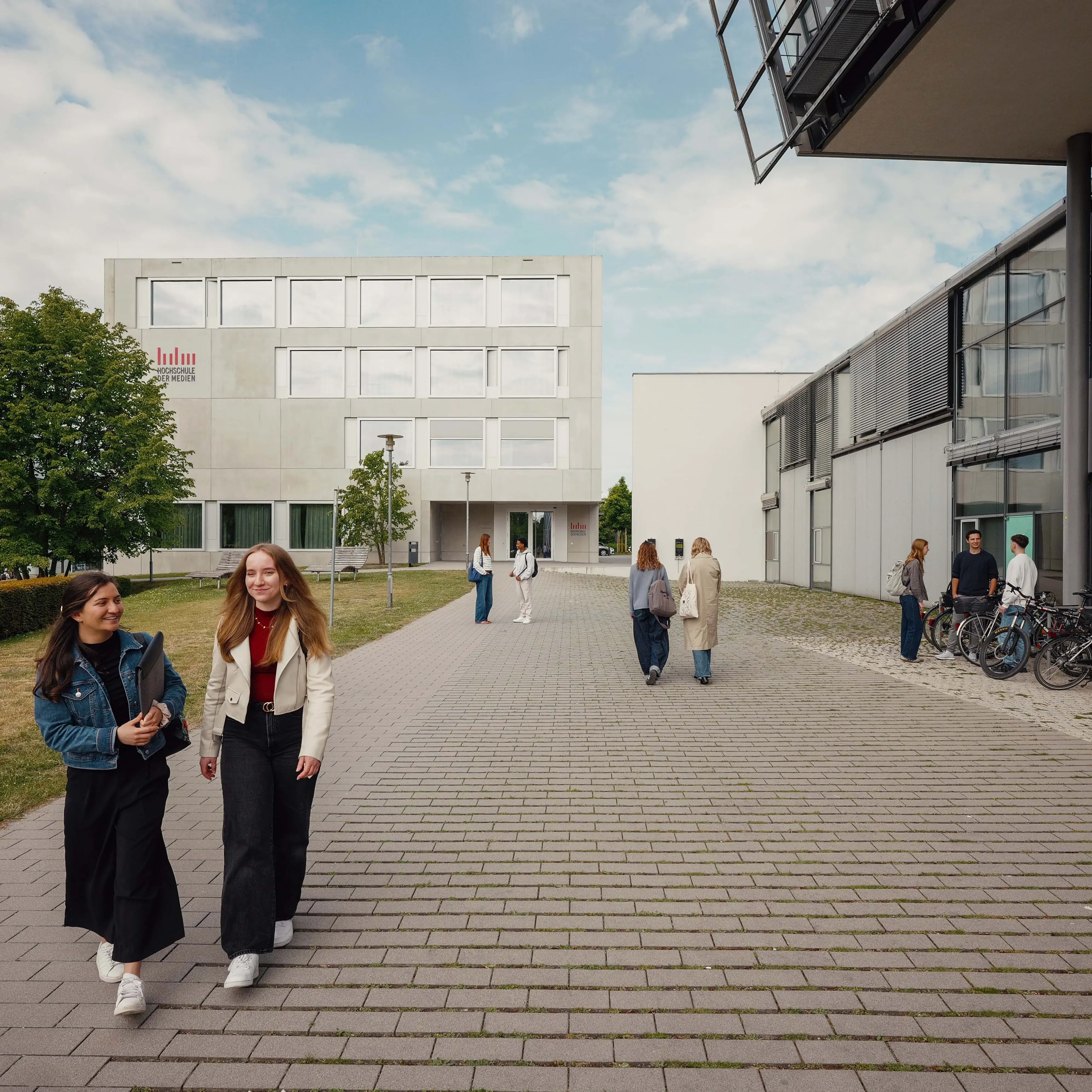 Studierende vor dem sogenannten Würfel, einem Nebengebäude der Hochschule der Medien.