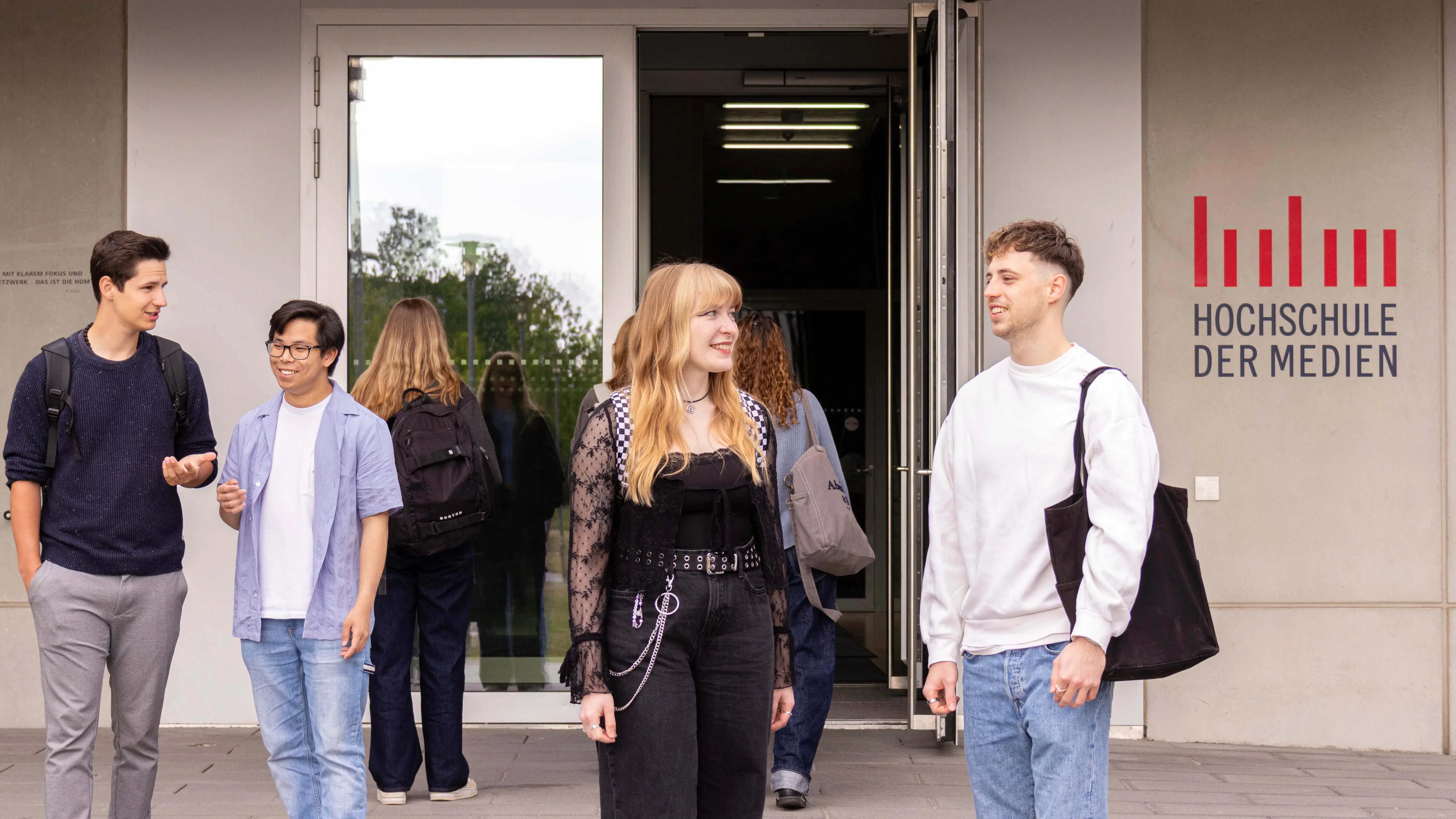 Studierende unterhalten sich vor dem sogenannten Würfel, einem Nebengebäude der Hochschule der Medien.