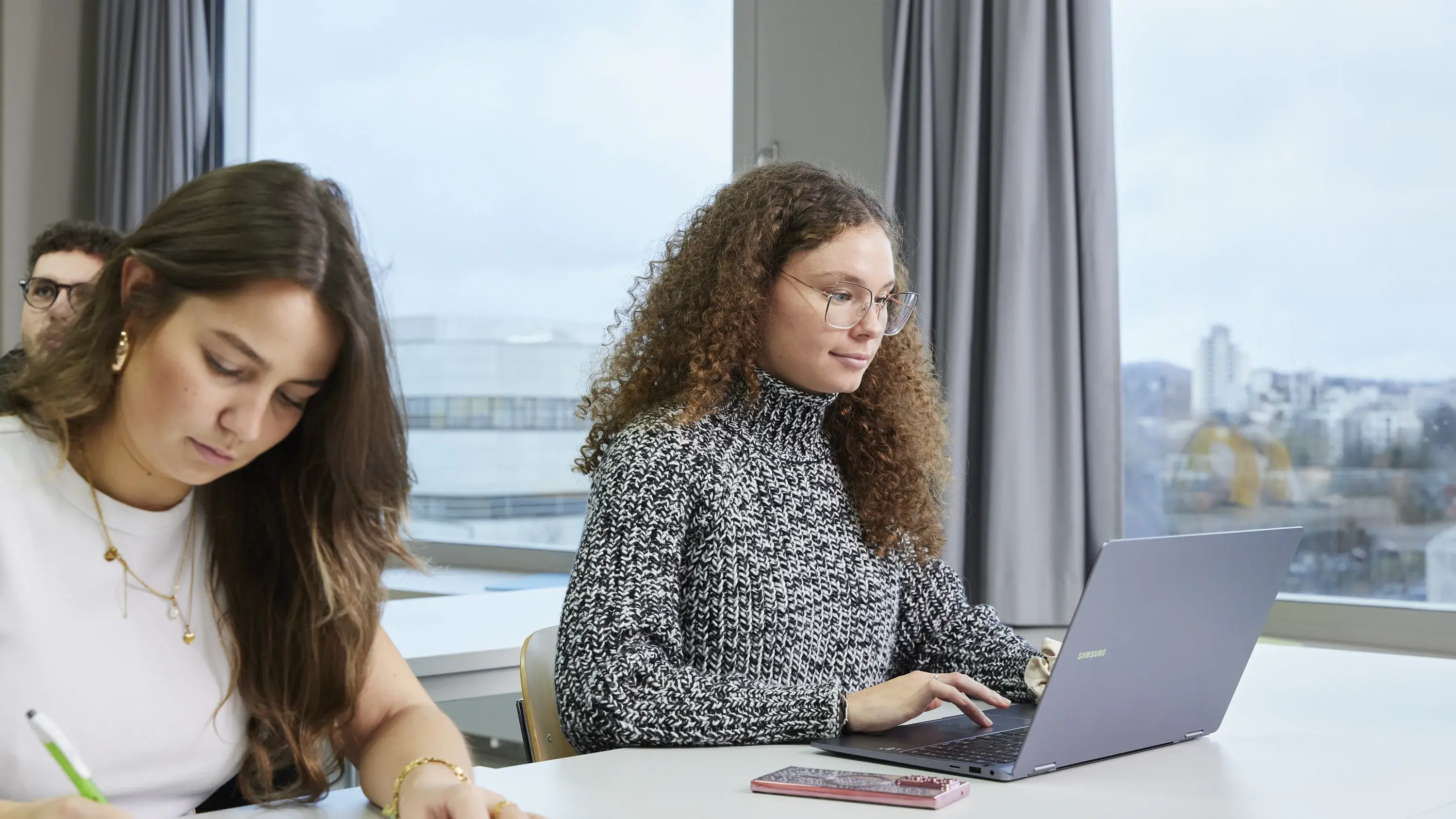 Studierende arbeiten konzentriert in einer Vorlesung.