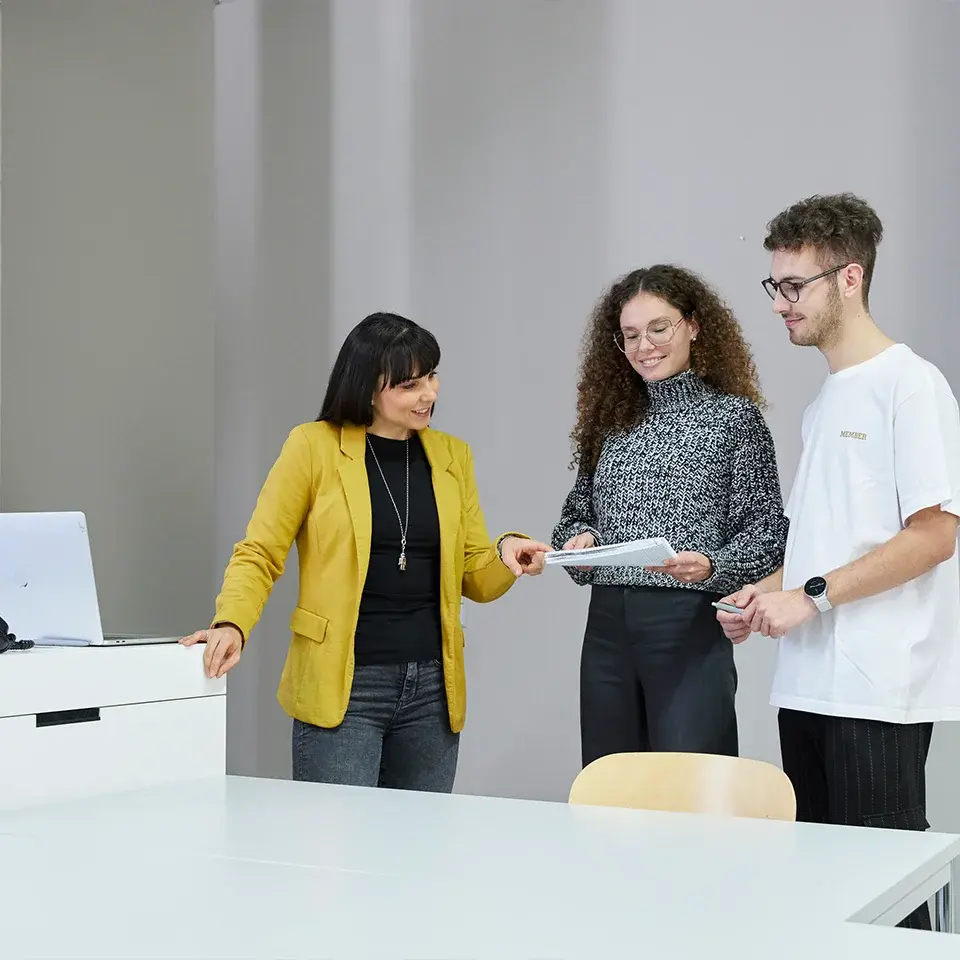 Das Bild zeigt Studenten in einem Vorlesungsraum während einer Präsentation.
