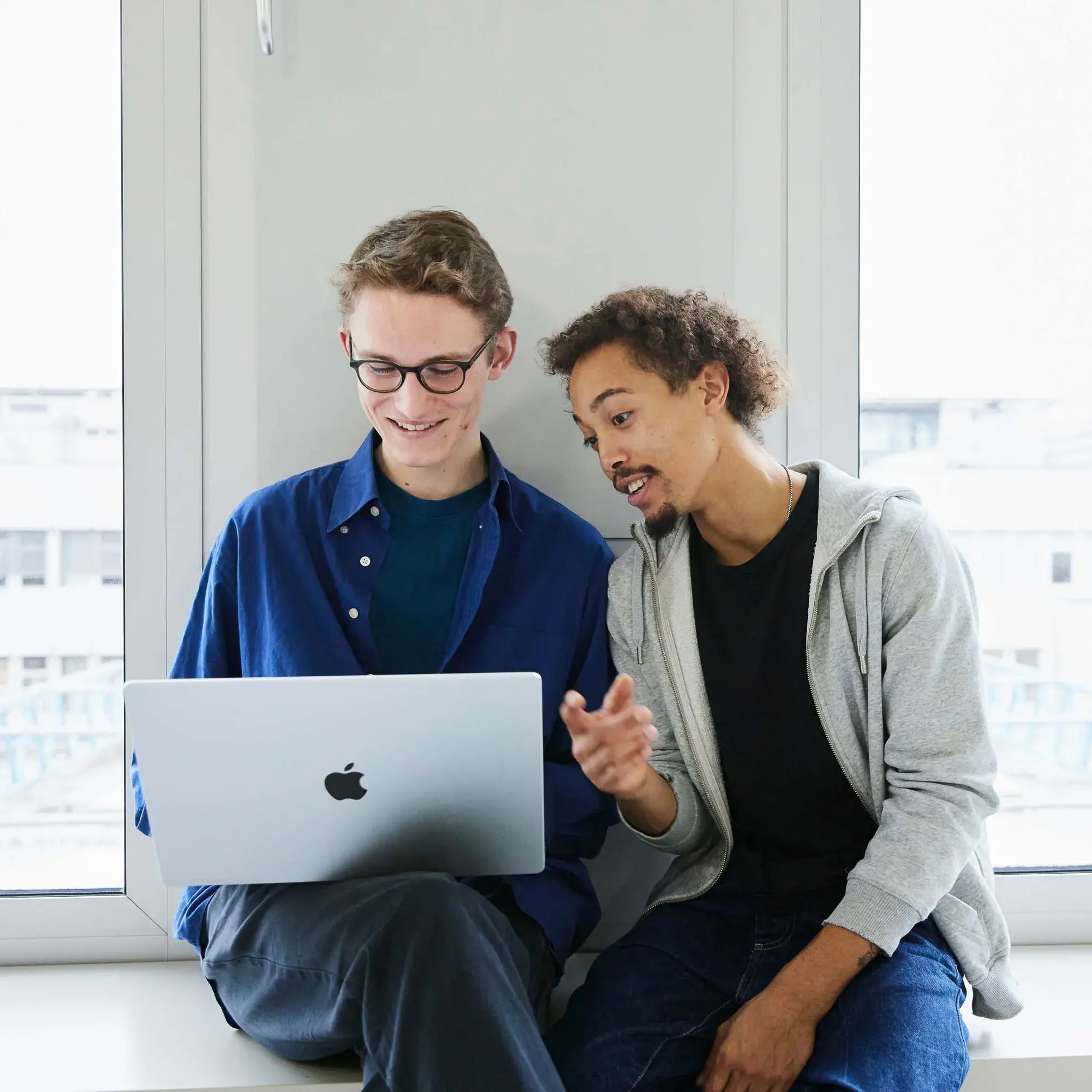 Zwei Studierende arbeiten an einem Laptop.