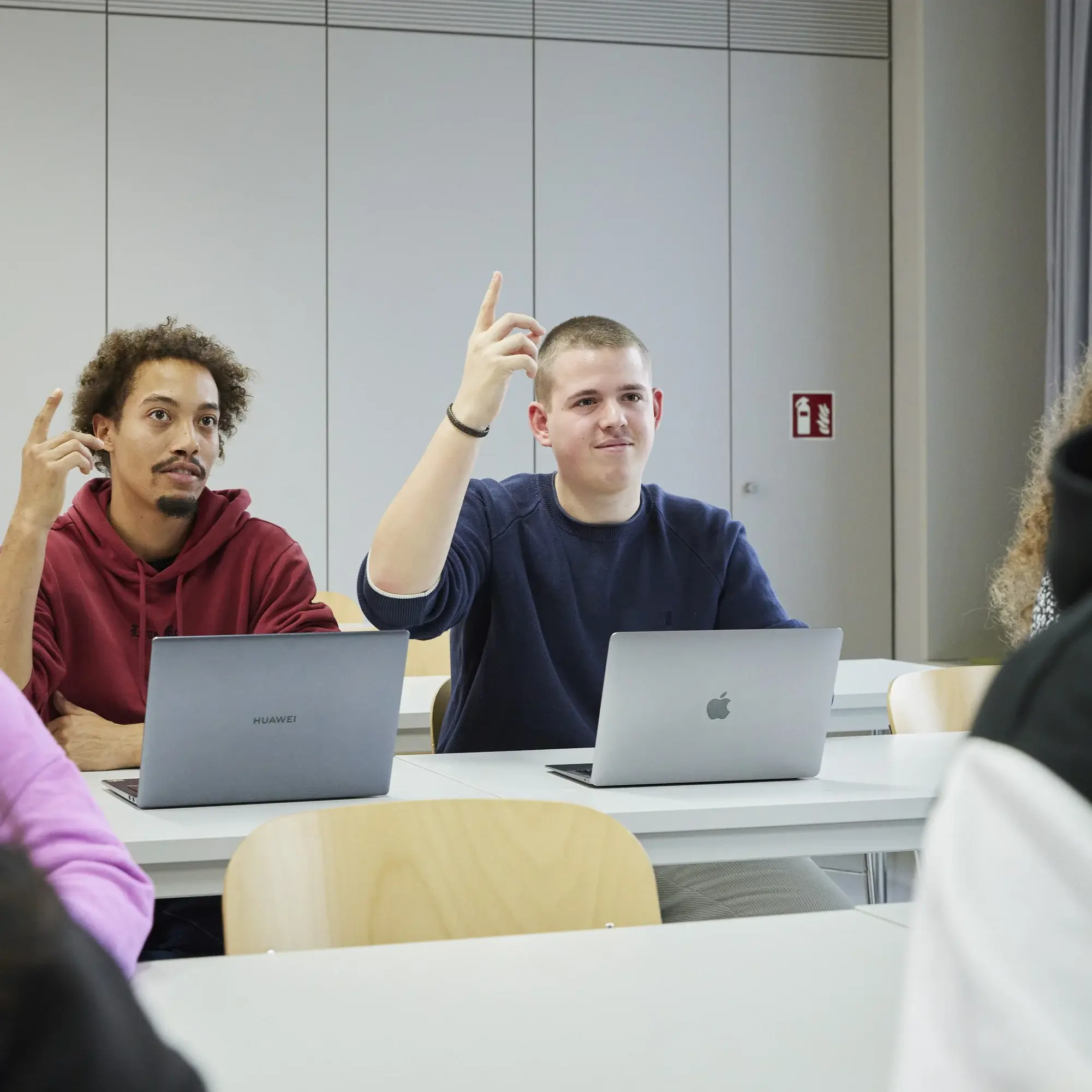 Zwei Studierende melden sich in der Vorlesung.