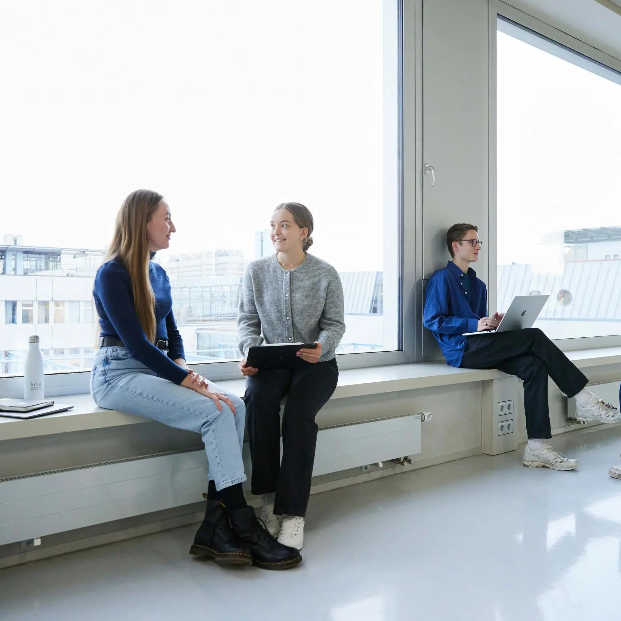 Studierende unterhalten sich in kleinen Grüppchen.