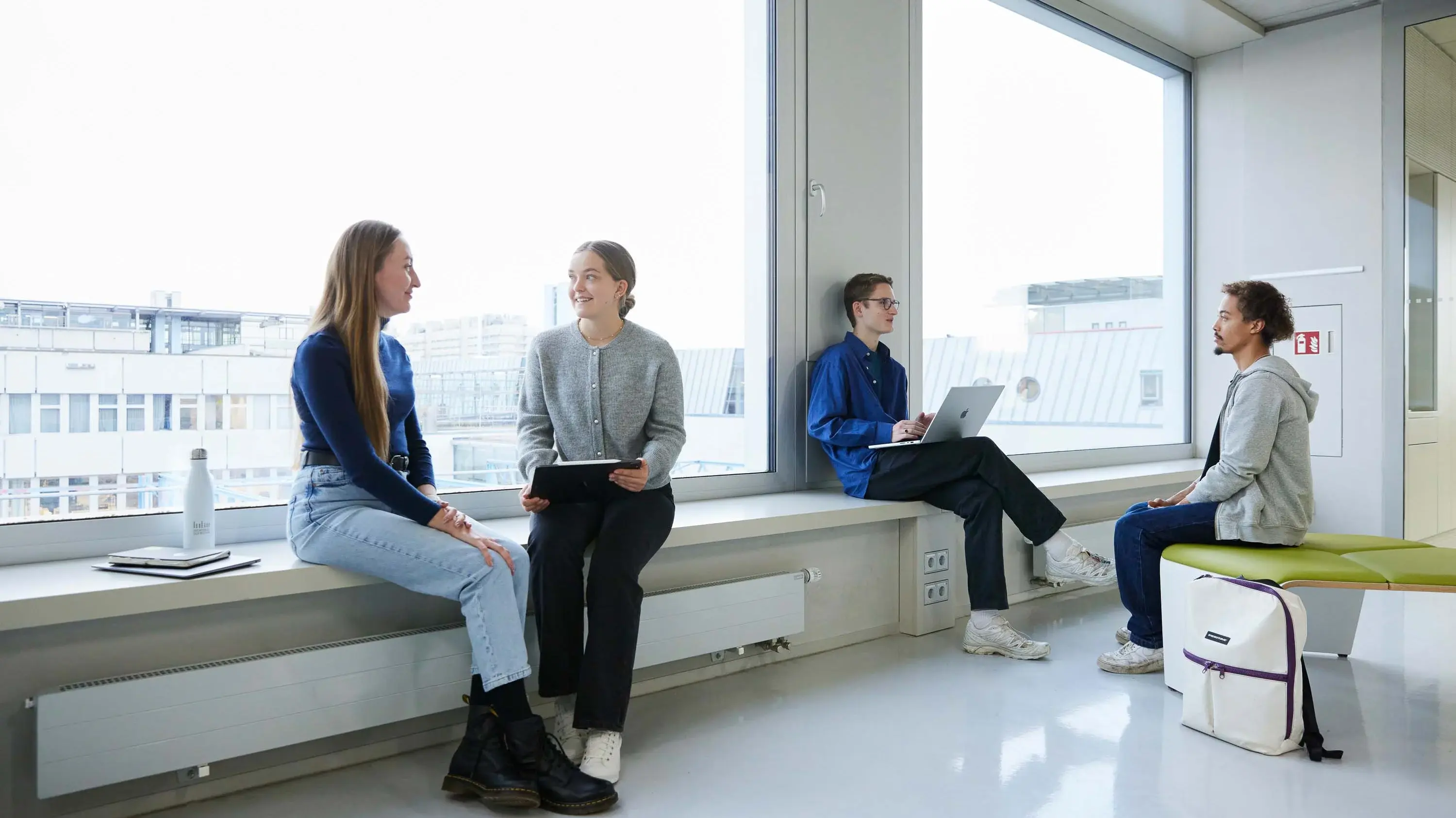 Studierende unterhalten sich in kleinen Grüppchen.
