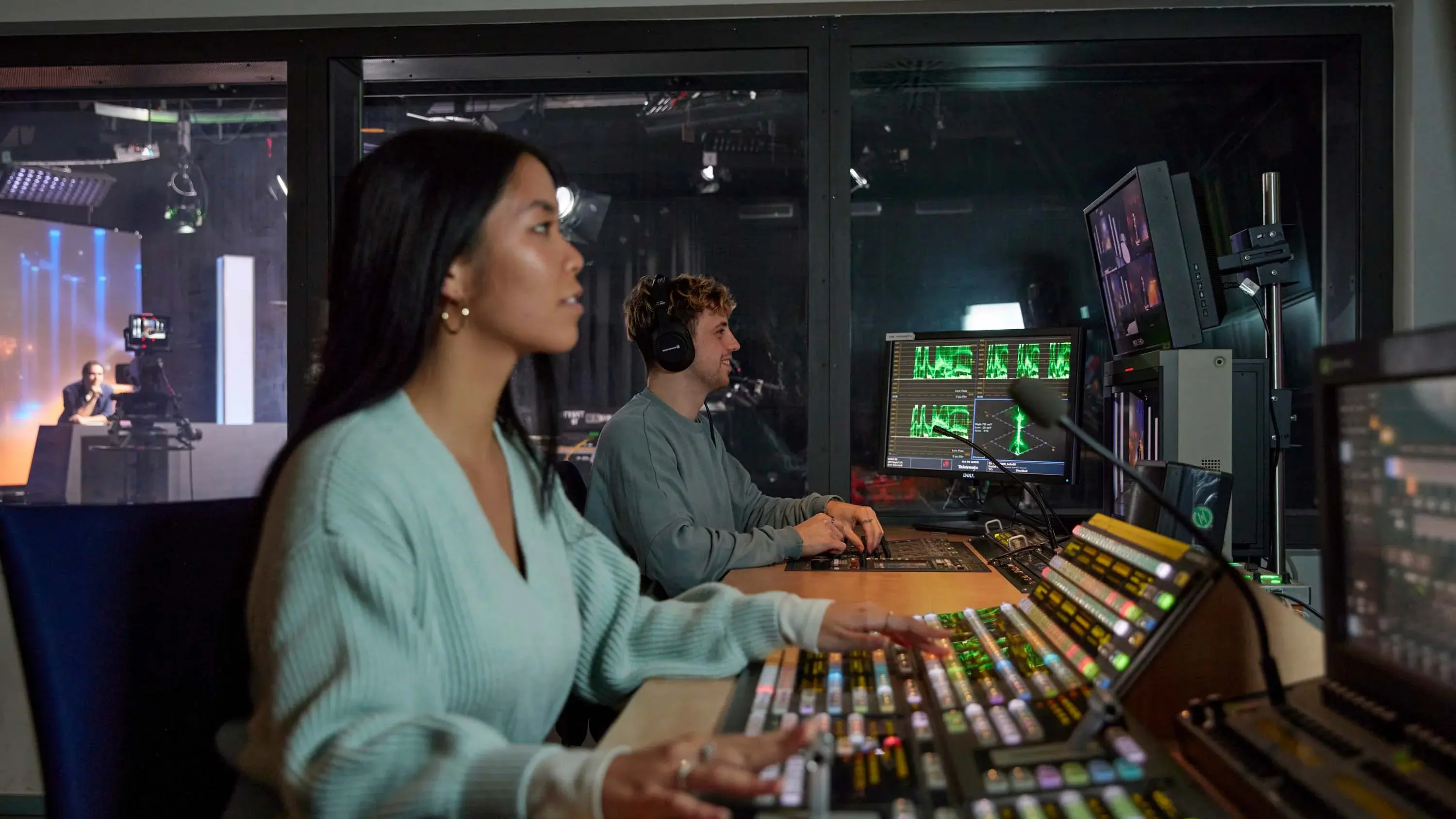 Im Technikraum des Fernsehstudios überwacht und betreut eine Studentin die Aufnahme einer Sendung.