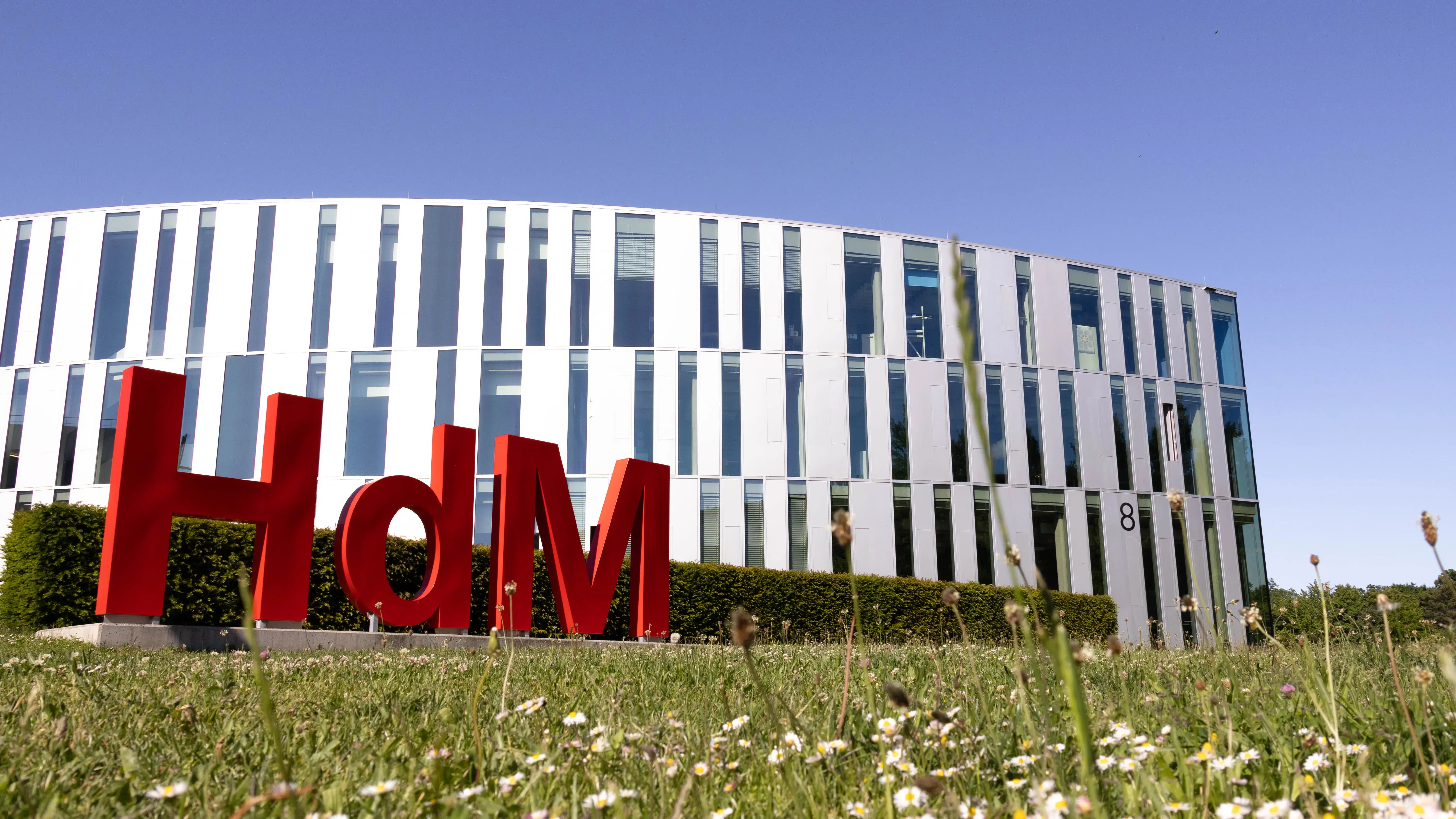 Eine Hollywood-Schriftzeichen-Imitation mit den Buchstaben H,d und M, ziert den Campus der Hochschule der Medien vor dem sogenannten Zitronenschnitz-Gebäude.