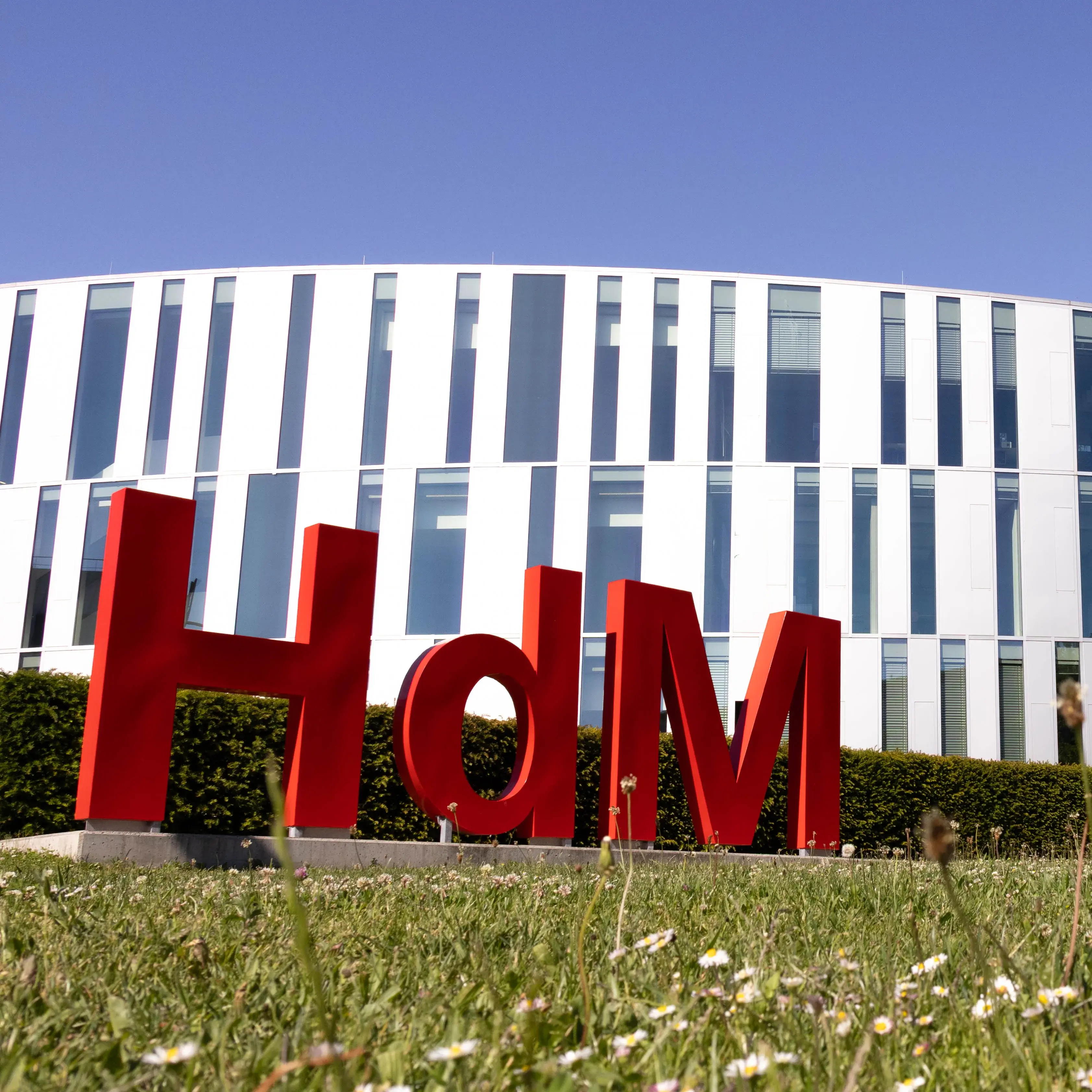 Eine Hollywood-Schriftzeichen-Imitation mit den Buchstaben H,d und M, ziert den Campus der Hochschule der Medien vor dem sogenannten Zitronenschnitz-Gebäude.