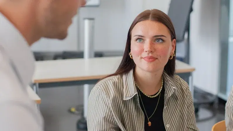 Eine Studentin im Gespräch mit einem Dozenten