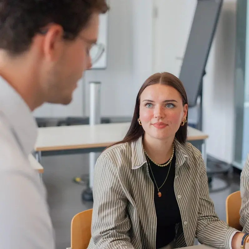 Eine Studentin im Gespräch mit einem Dozenten