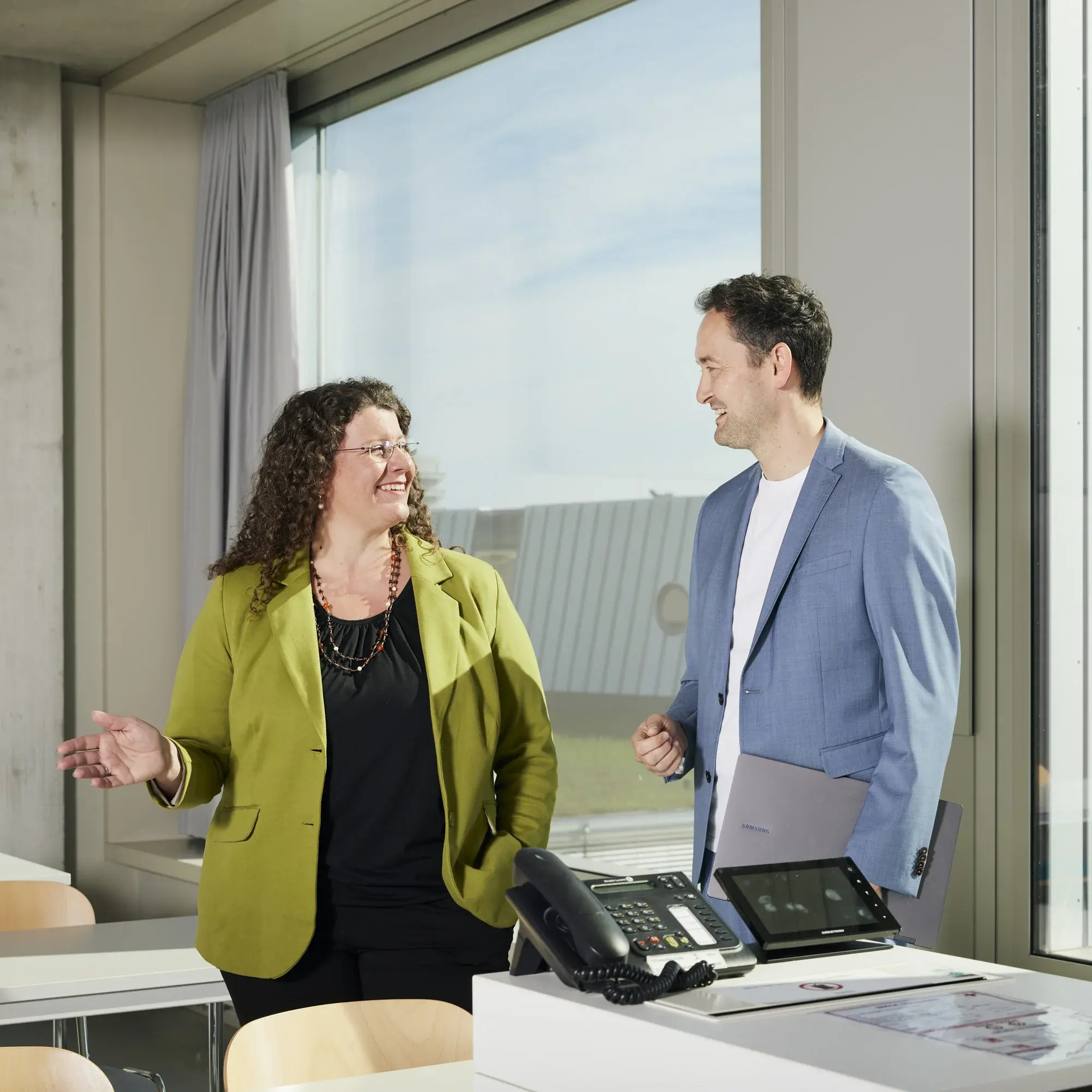Professorin Dr. Nicole Lindemann und Professor Dr. Stephen Schuster unterhalten sich im leeren Vorlesungssaal.