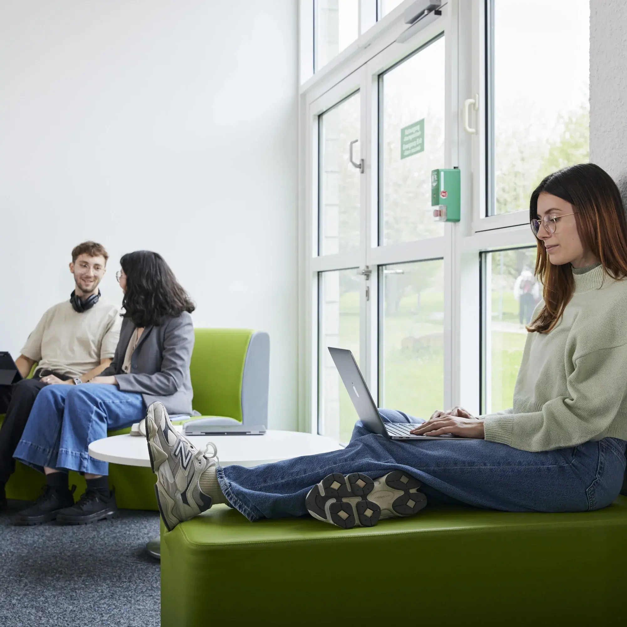 Studierende lernen und arbeiten in verschiedenen Sitzgelegenheiten.
