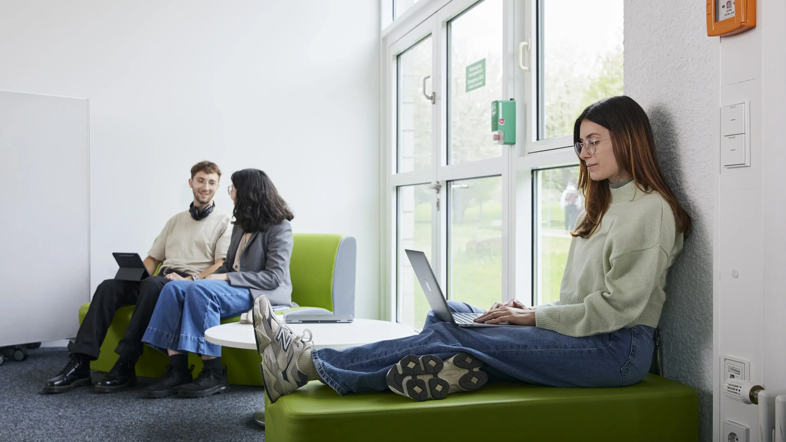 Studierende lernen und arbeiten in verschiedenen Sitzgelegenheiten.
