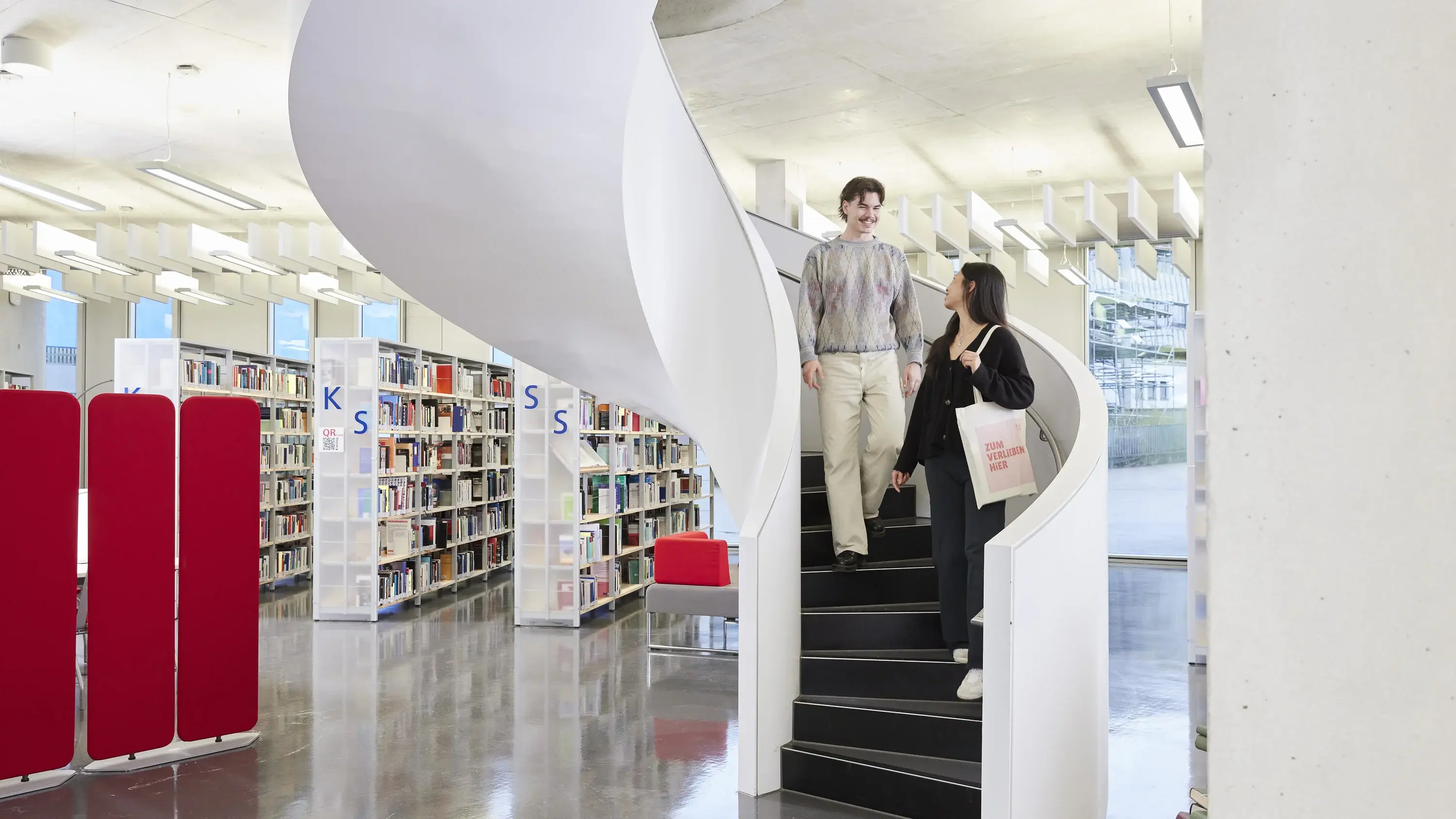 Studierende auf der Treppe in der Bibliothek der Hochschule der Medien.