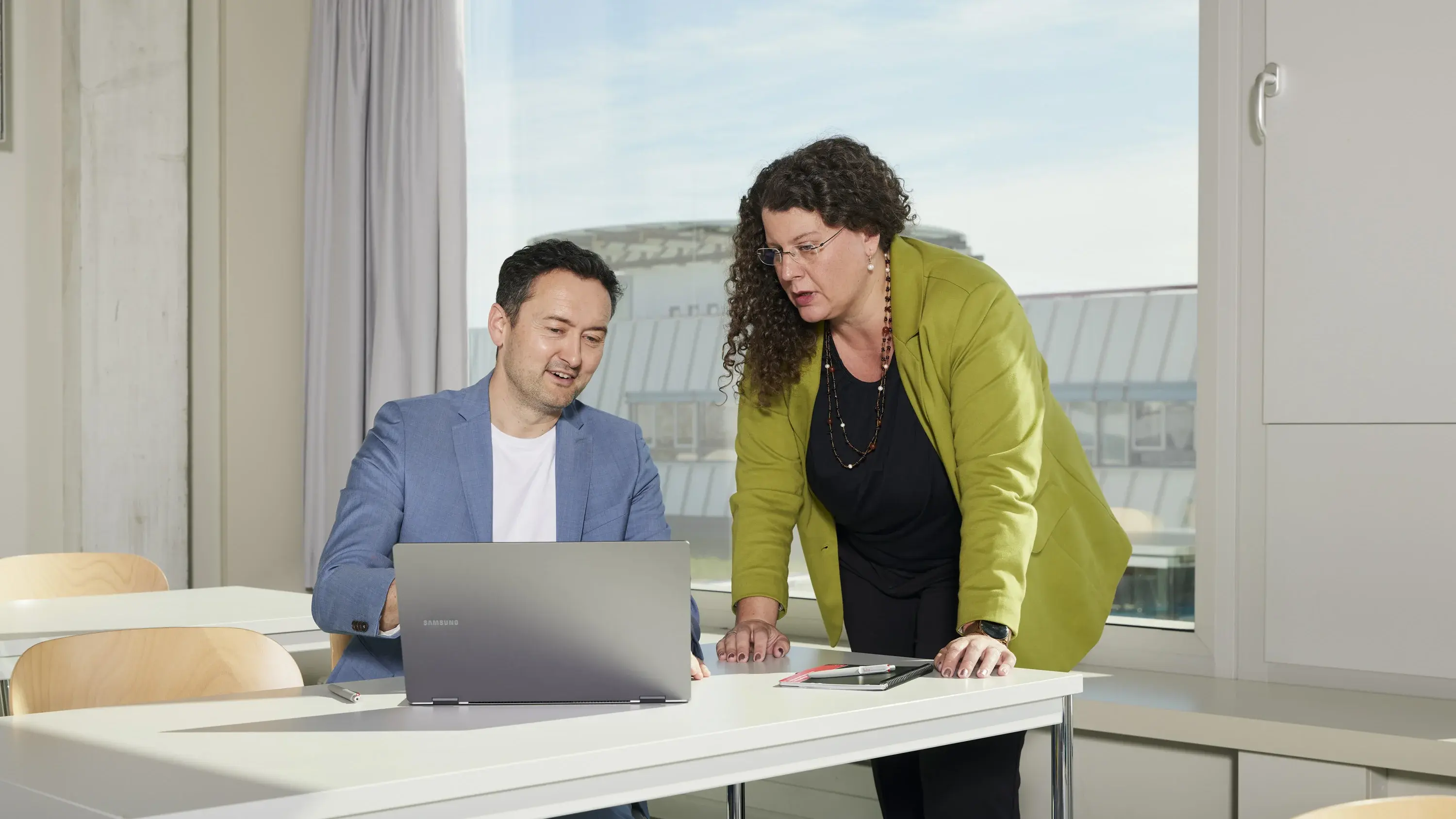 Professorin Dr. Nicole Lindemann und Professor Dr. Stephen Schuster unterhalten sich im leeren Vorlesungssaal.