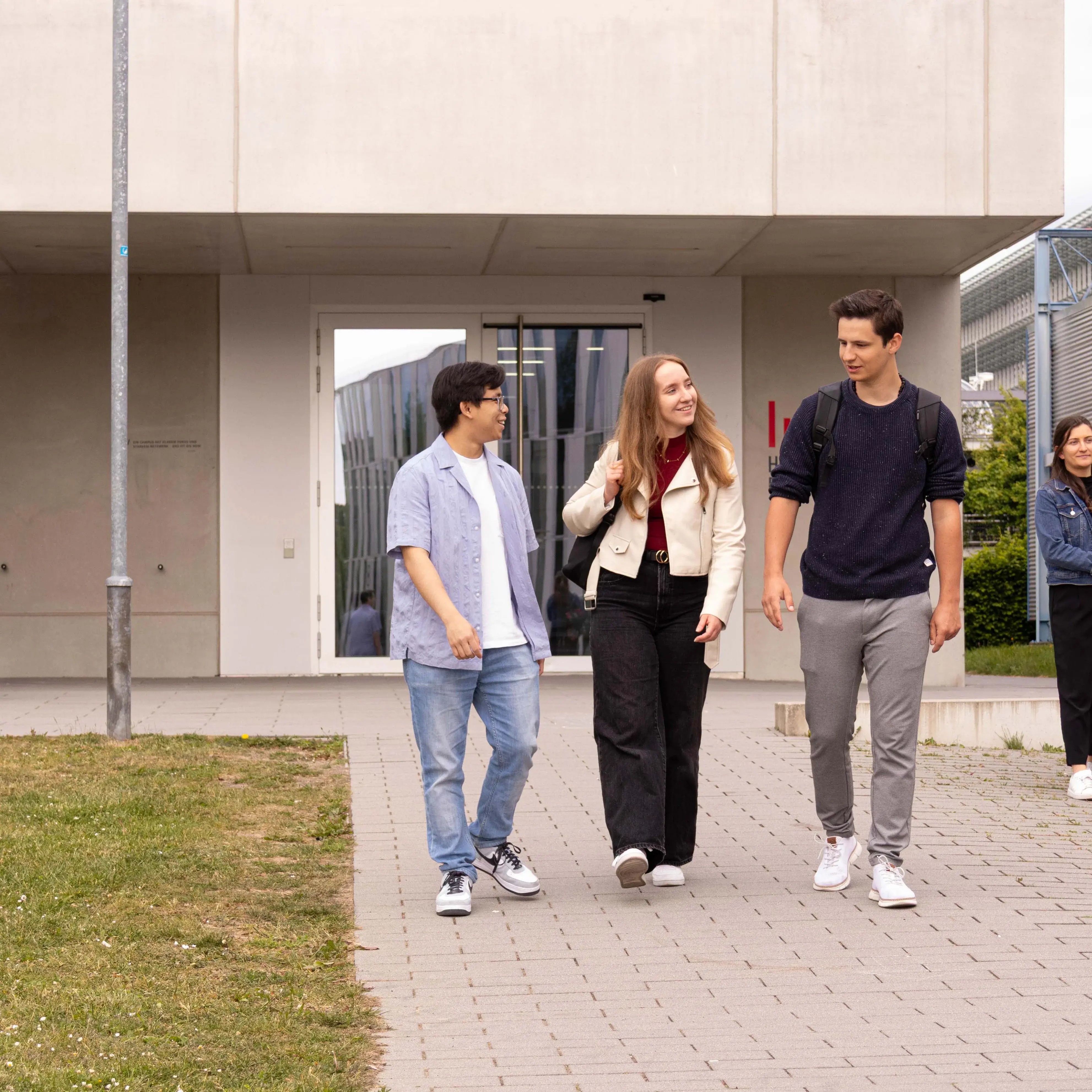 Studierende unterhalten sich beim Verlassen der Hochschule der Medien.