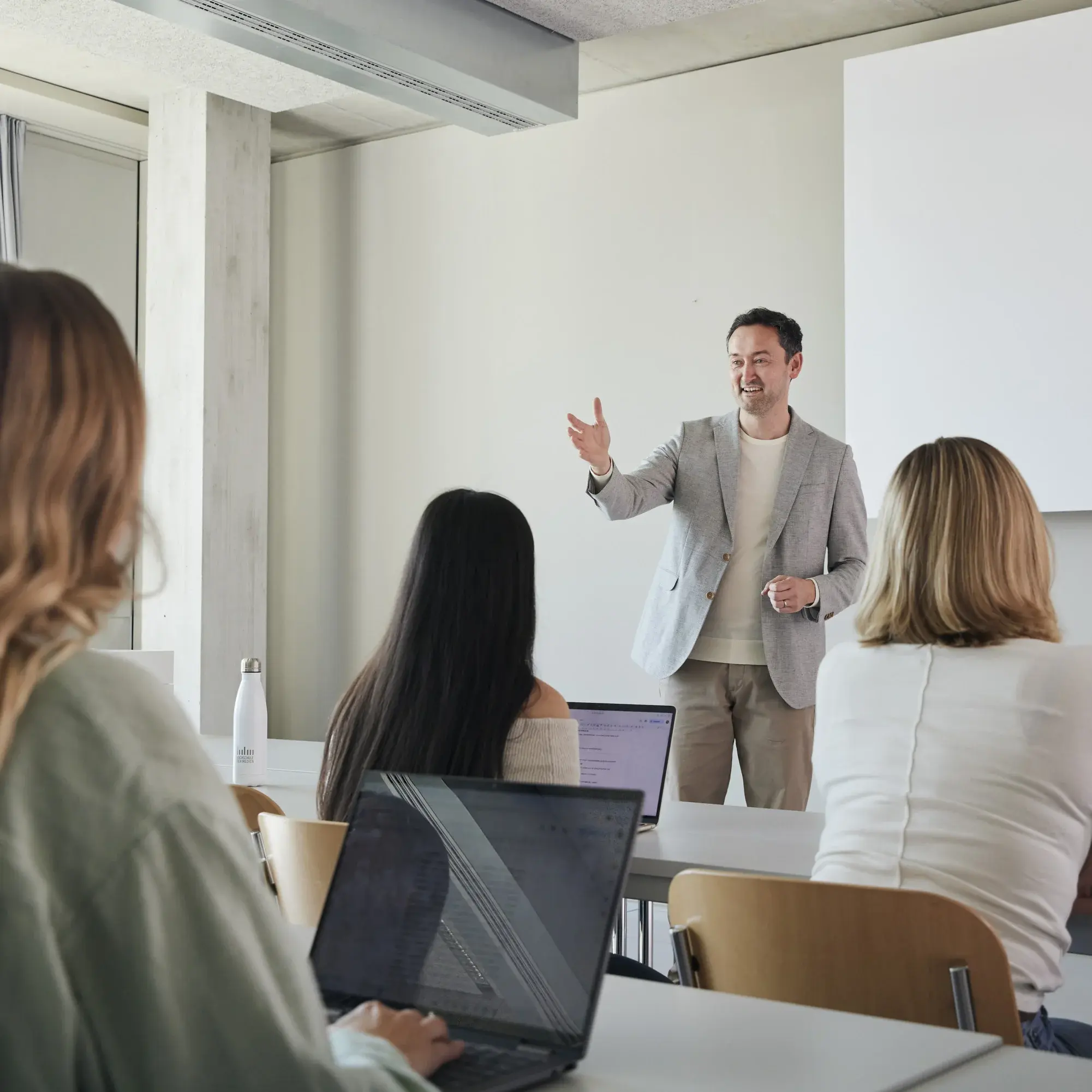 Ein Professor mit seinen Studierenden in der Vorlesung.