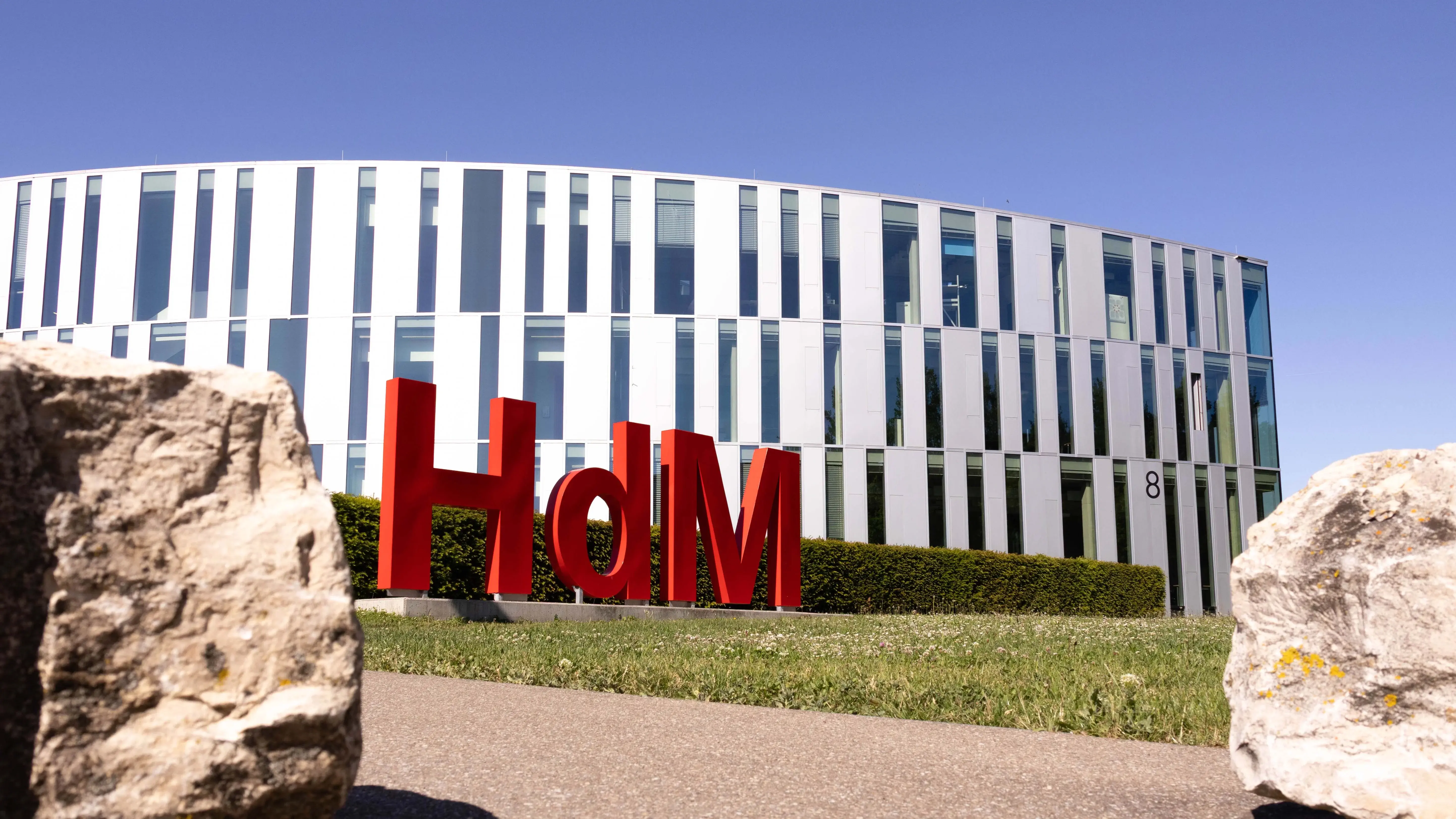 Eine Hollywood-Schriftzeichen-Imitation mit den Buchstaben H,d und M, ziert den Campus der Hochschule der Medien vor dem sogenannten Zitronenschnitz-Gebäude.