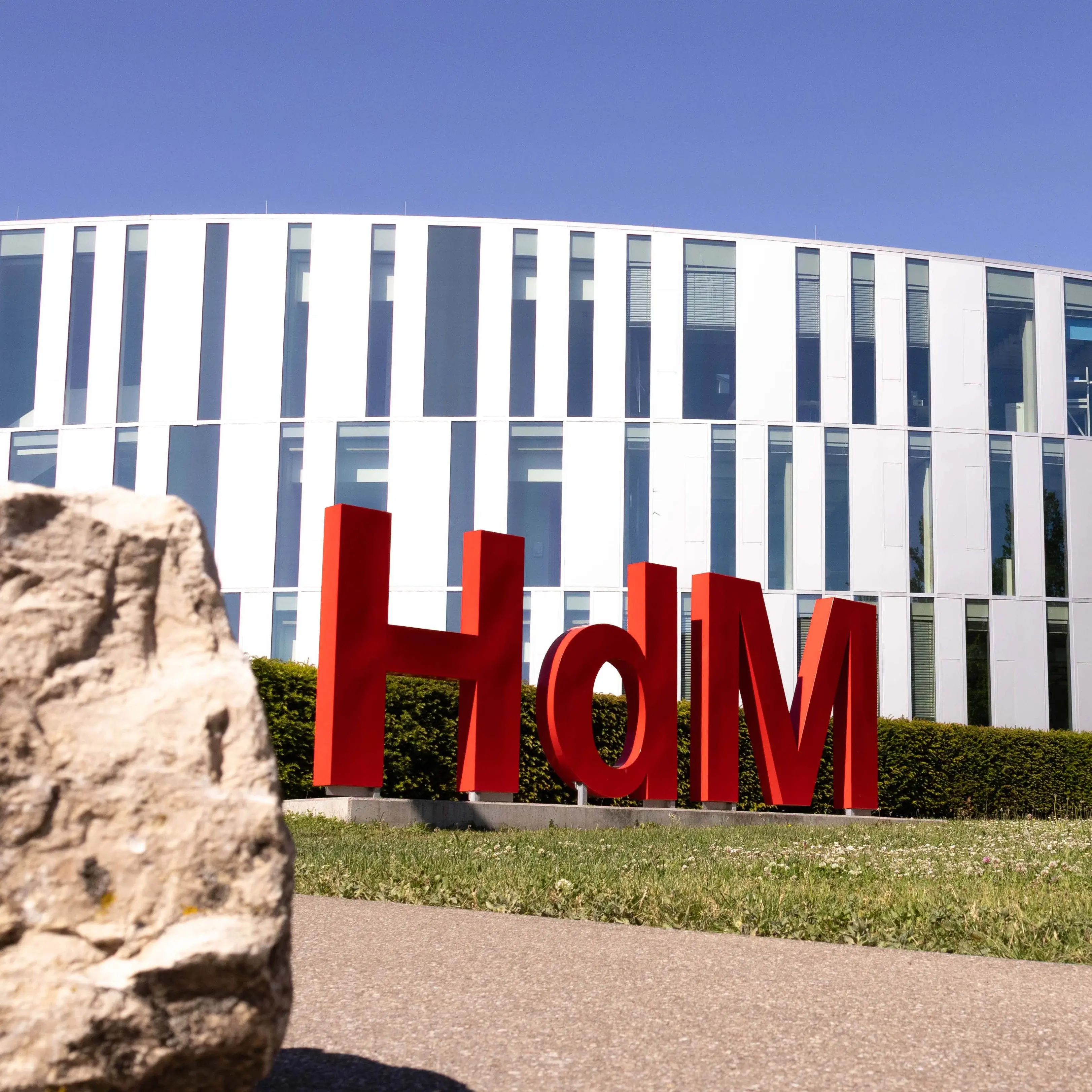 Eine Hollywood-Schriftzeichen-Imitation mit den Buchstaben H,d und M, ziert den Campus der Hochschule der Medien vor dem sogenannten Zitronenschnitz-Gebäude.