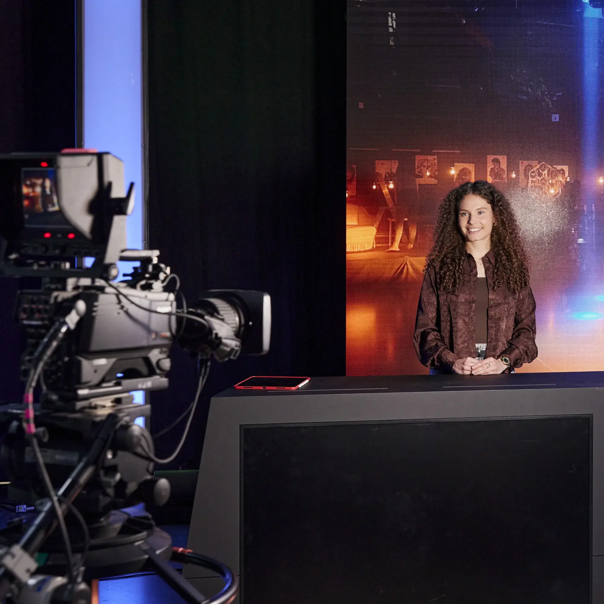 Im Fernsehstudio der HdM wird die Moderation einer Studentin aufgezeichnet.