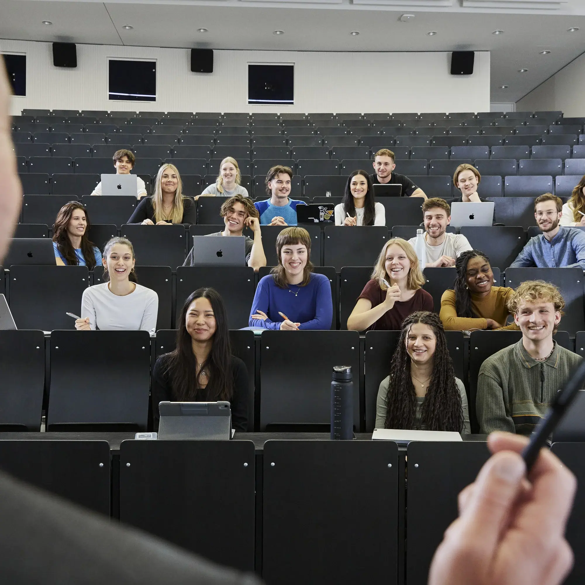 Professor steht vor Studierenden in einem Vorlesungssaal.