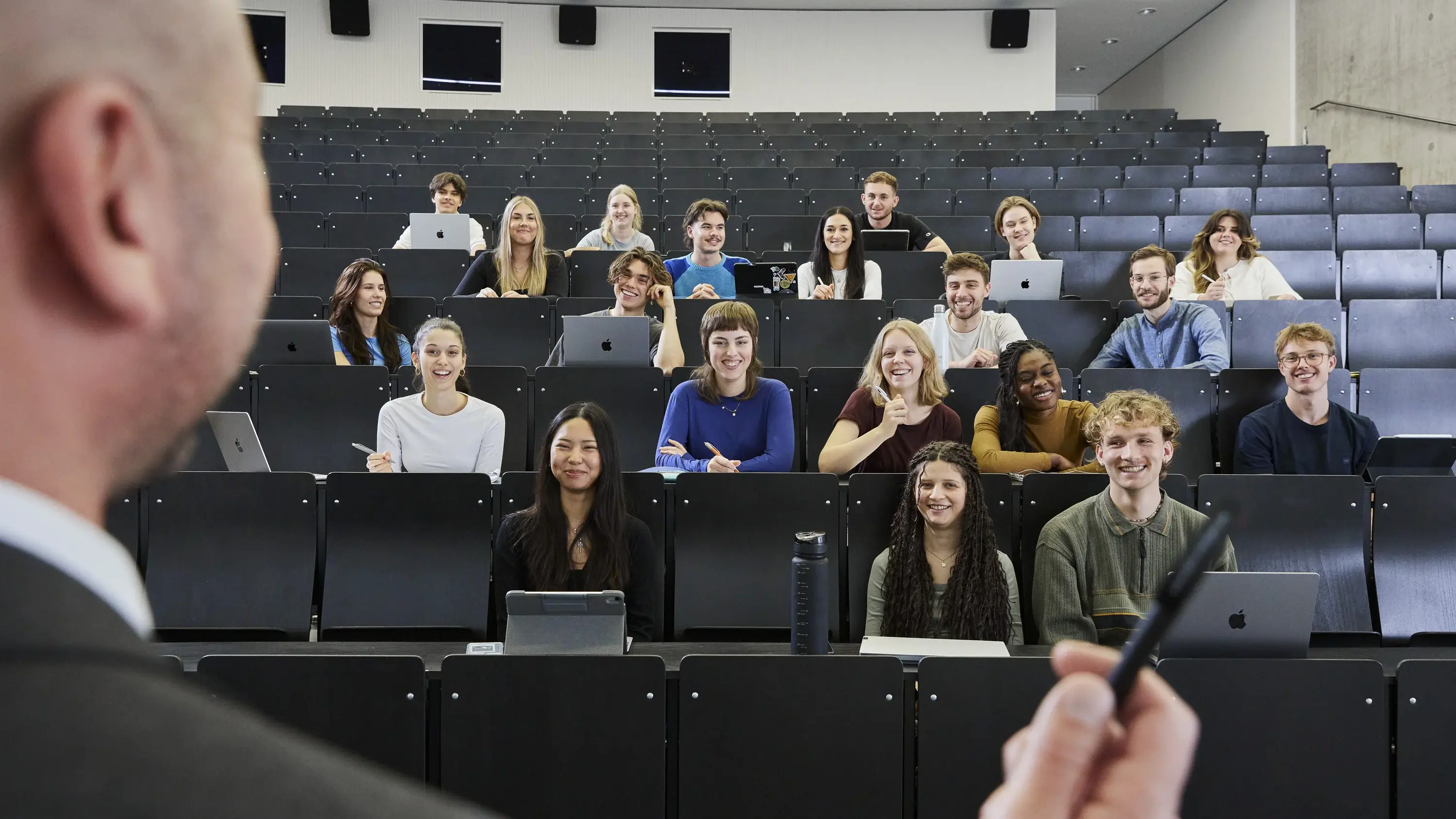Professor steht vor Studierenden in einem Vorlesungssaal.