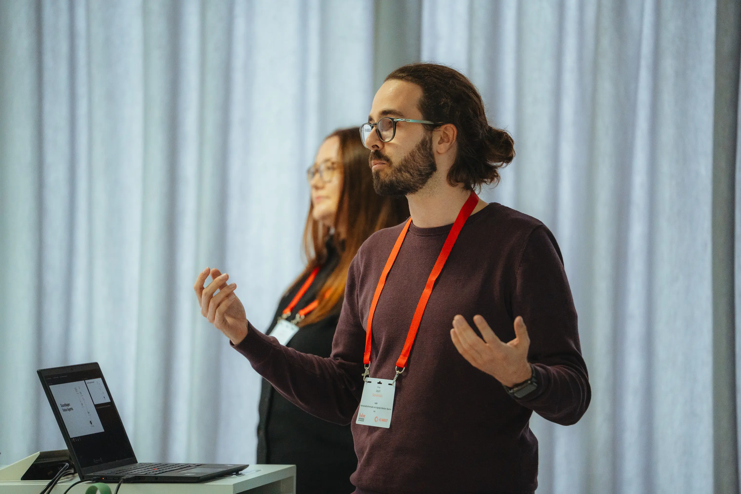 Zwei Personen halten einen Vortrag.